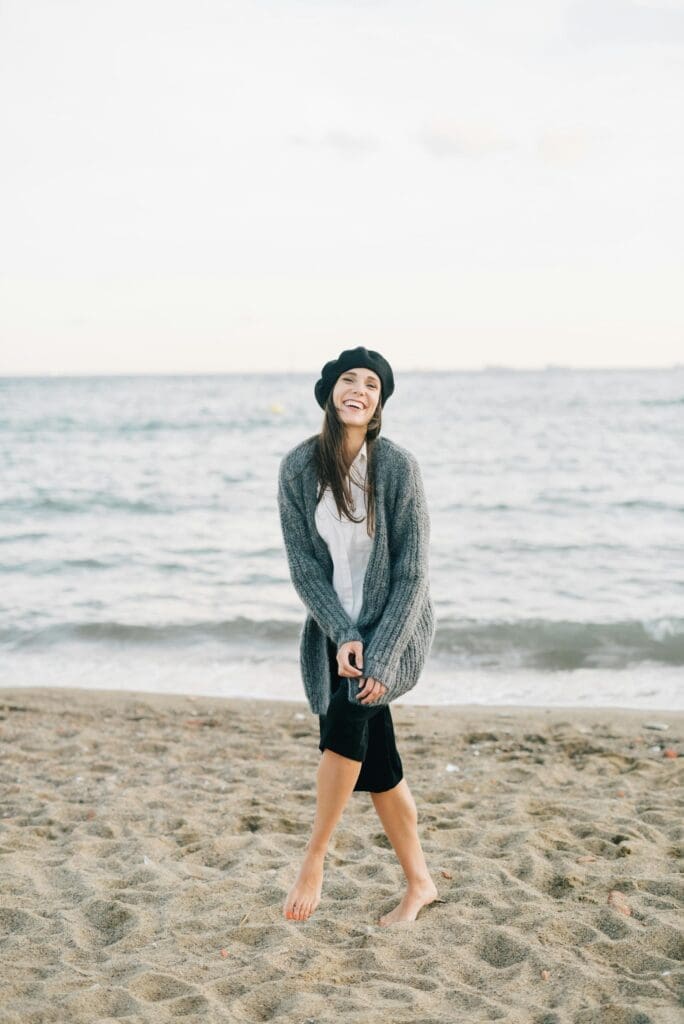 Relaxed woman smiling on beach after visiting a bio-well practitioner in Kona